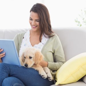 woman using computer with her dog on the couch at apartments in wilmington de